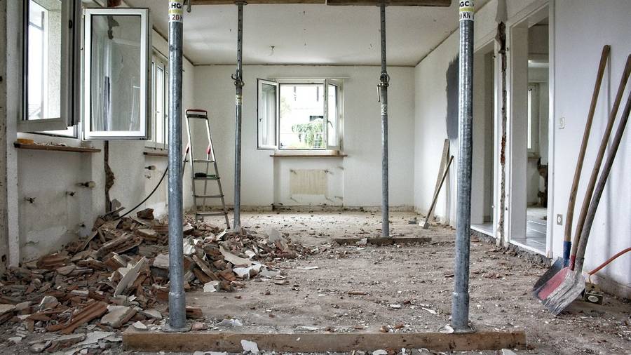 Stripped-back interior of a property mid-renovation with temporary supports in place